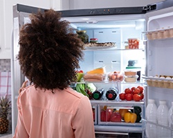 person looking in her refrigerator